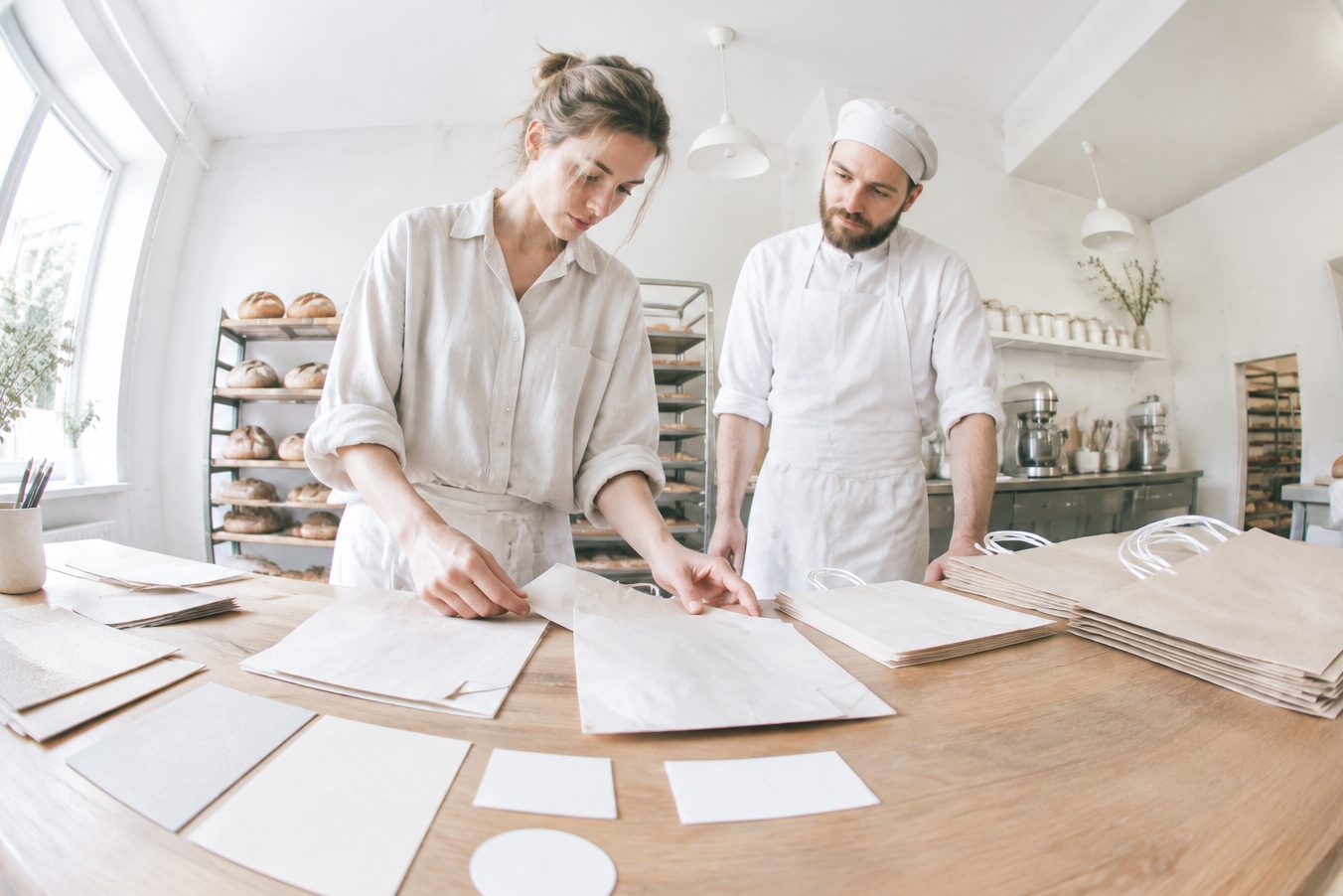 A designer places new bags and labels on a bakery counter