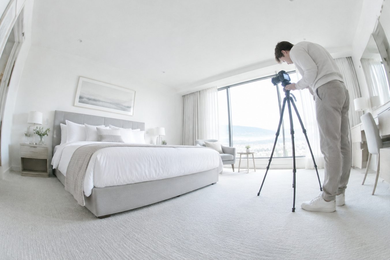 A photographer sets up a camera in a hotel room